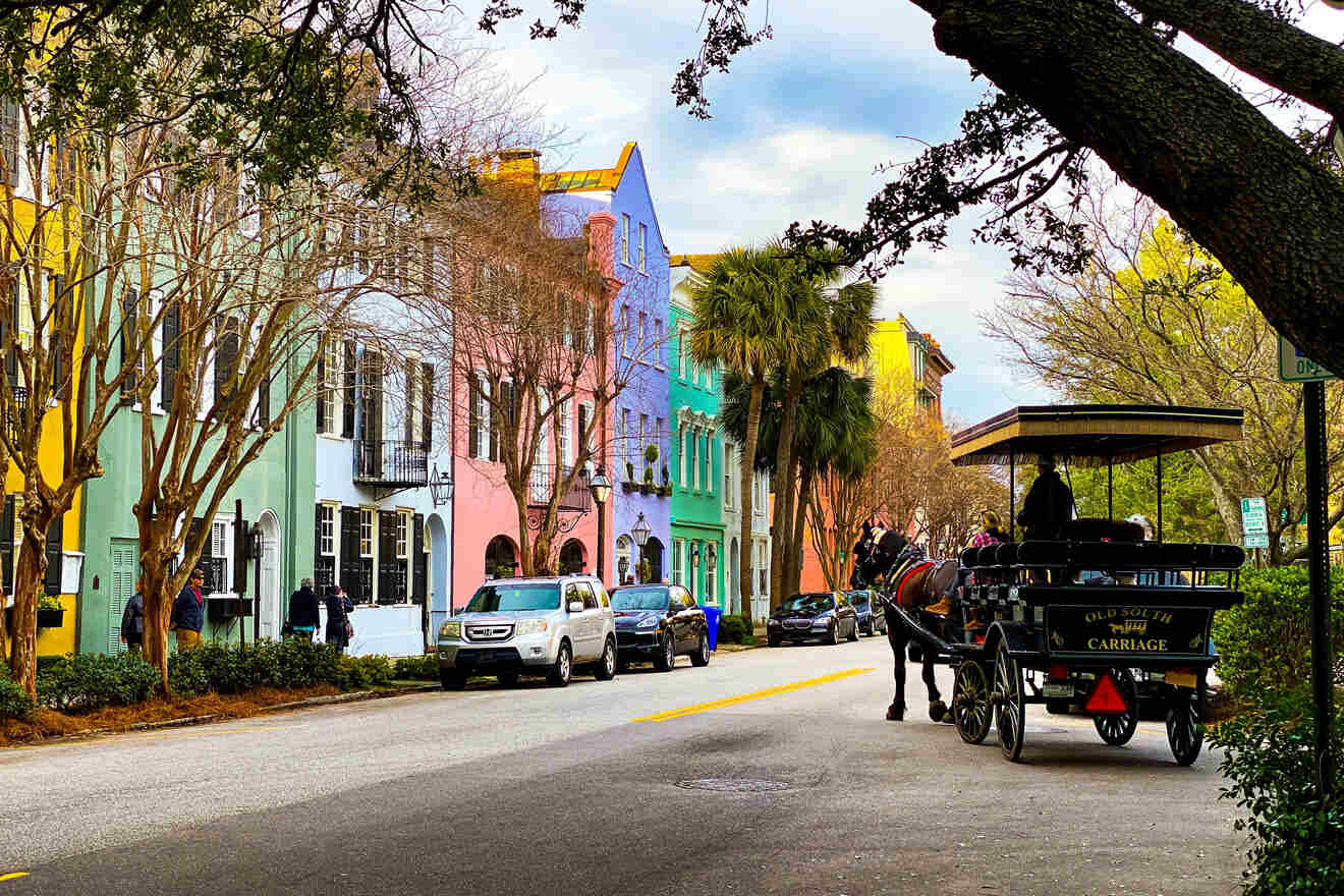 Street-level scene in Charleston, South Carolina, featuring pastel-colored historic buildings, a horse-drawn carriage labeled 'Old South Carriage,' and verdant trees along the sidewalk.